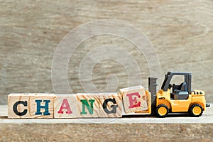 Toy yellow forklift hold block letter e to complete word change