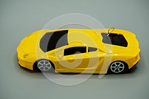toy yellow luxury car. yellow diecat toy modren car with antena isolated on gray background.