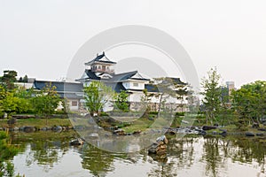 Toyama castle with beautiful garden and reflection in water.