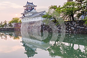 Toyama castle with beautiful sunset and reflection in water.