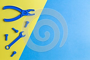 Toys background. Kids construction toys tools on blue and yellow background. Top view