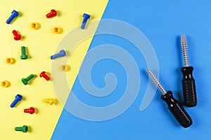 Toys background. Kids construction toys tools on light blue and yellow background. Top view