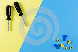 Toys background. Kids construction toys tools on blue and yellow background. Top view