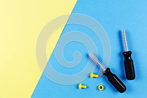 Toys background. Kids construction toys tools on blue and yellow background. Top view