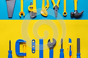 Toys background. Top view of toy tools on blue yellow background