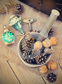 Toys for the Christmas tree and pine cones on old wooden background