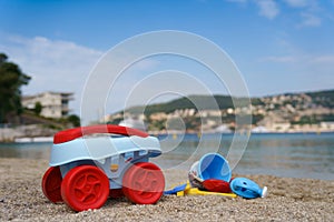 Toys lie on sand of beach near sea