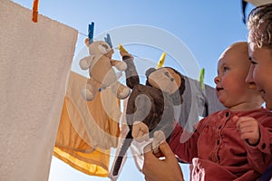 Toys monkey and teddy bear are dried on a clothesline after washing