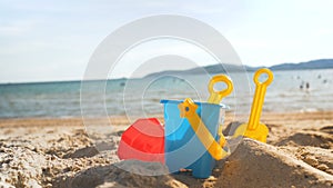 Toys on the sand beach with sea wave select focus shallow depth of field with summer atmosphere