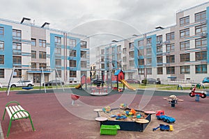 Toys in sandbox children playground house building exterior mixed-use urban multi-family residential district area