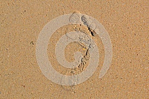 Trace of a bare foot of the person on sand