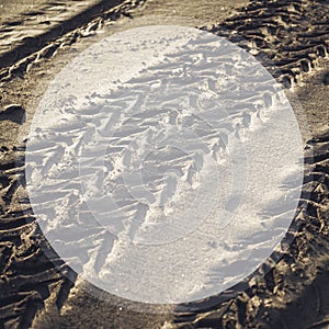Trace from car tyres on wet sand in a frame