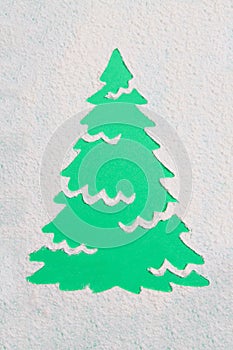 A trace from a stencil in the shape of a Christmas tree made of flour on a green background. Ideas for festive baking and decorati