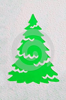 A trace from a stencil in the shape of a Christmas tree made of flour on a green background. Ideas for festive baking and decorati