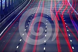 Traces of car headlights on the background of the paved road. Abstract lines background