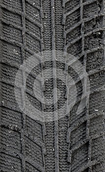 Traces of car tire tread in the ground. Pattern. Dark abstract background. Imprint of wheels. Textured soil. Drawing