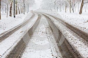 Traces of car tires on the street during heavy snowstorm