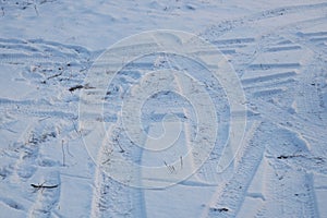 Traces of car tyres on the snow in winter