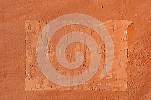 Traces of old announcements on terracotta wall. Background texture