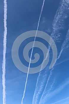Traces of planes and clouds. Blue sky with plane trails.