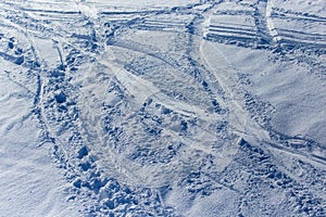 Traces of skiers on white snow in the mountains