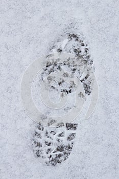 Traces on snow. The imprint of a large man's shoe in the snow.