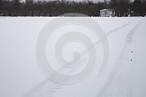 Traces of a vehicle on a level surface untouched snow