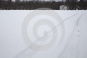 Traces of a vehicle on a level surface untouched snow photo