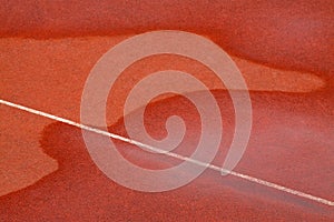 Traces of water on red plastic runway