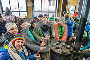 Tourists bask at the stove in the base camp`s cabins at the Thor