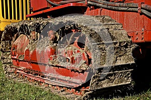 Track of a bulldozer caked with mud