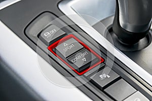 Track control buttons near automatic gear stick of a modern car, car interior details.