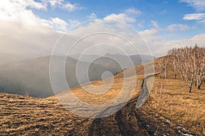 Track in the mountains in the fall, rocks, forest and sky