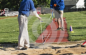 Track officials measuring a jump