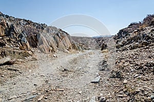 Track running through rocky arid desert scenery in ancient Namib Desert of Angola