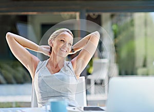 On track to success. a contented businesswoman leaning back with her hands behind her head.