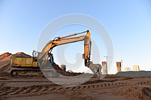Track-type excavator during earthmoving at construction site. Backhoe digg ground at construction site