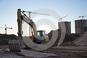 Track-type excavator during earthmoving at construction site. Backhoe digg ground at construction site for the construction