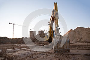 Track-type excavator during earthmoving at construction site. Backhoe digg ground at construction site for the construction