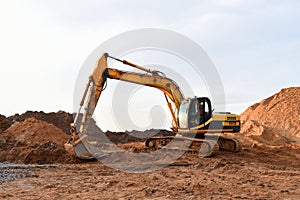 Track-type excavator during earthmoving works at open-pit mining. Loader machine with bucket in sand quarry. Backhoe digging the