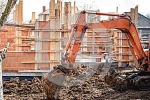 Track-type excavator loader working and loading at house construction site