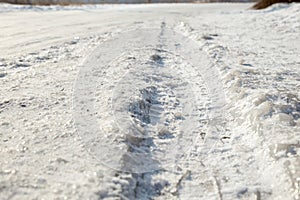 Track from a wheel on an icy track. Dangerous driving conditions. Icy road with tracks from the wheels of cars. The concept of