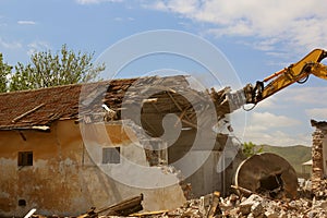 Tracked excavator demolishing old buildings