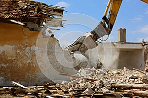 Tracked excavator demolishing old buildings