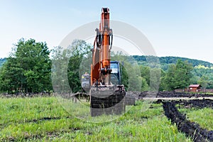 Tracked excavator tool on focus near a small river