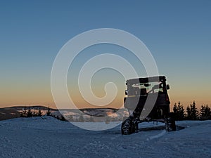 Tracked UTV in the snow during sunset
