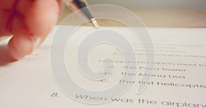 Tracking macro shot of pen marking answers in a history test in school