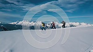 Tracking shot group of active sport backpacker wearing equipment going on white snow