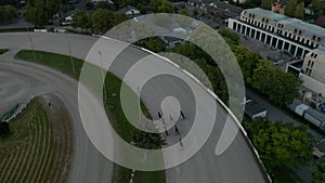 Tracking Shot of Horse Race on dirt track galloping fast, Aerial Birds Eye View