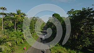 Tracking of vehicles overpassing slowly moving car of road leading through tropical forest. Costa Rica